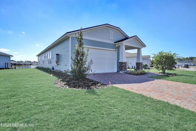 view of property exterior with a garage, decorative driveway, and a lawn