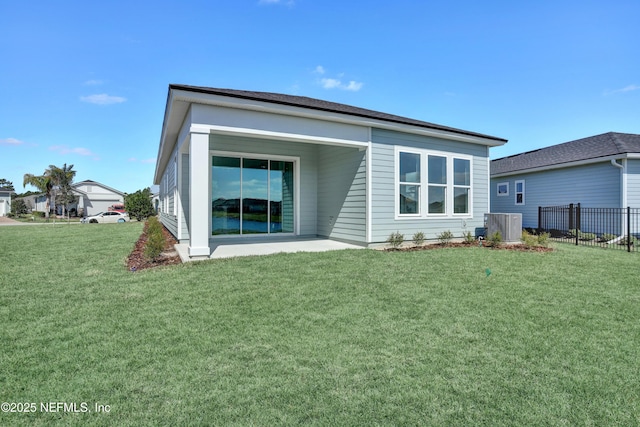 rear view of house featuring a yard, fence, and central air condition unit