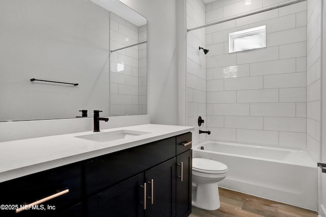 bathroom with shower / bathtub combination, vanity, wood finished floors, and toilet