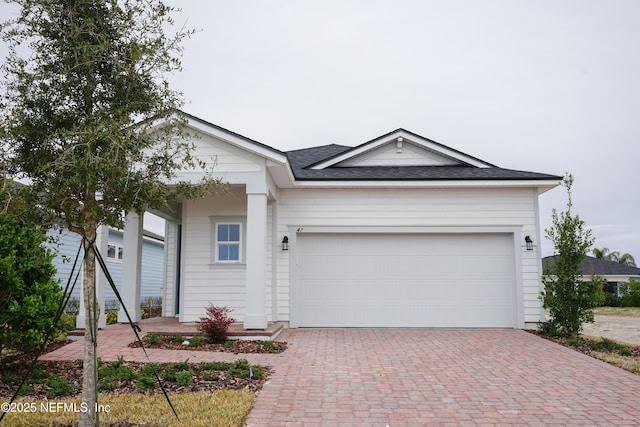 ranch-style house with a garage and decorative driveway