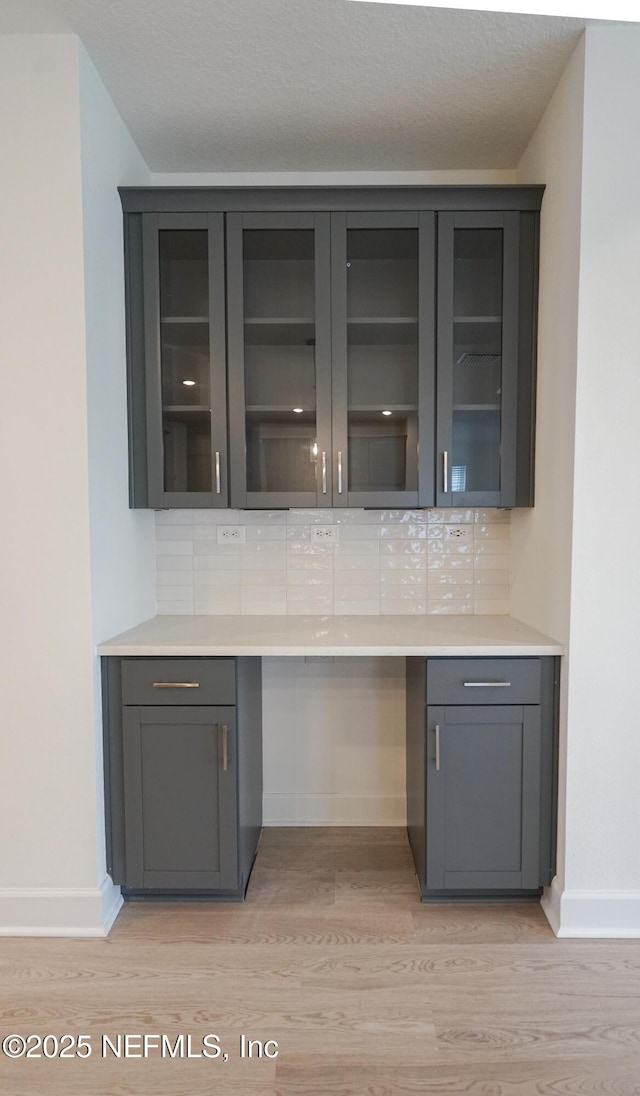 bar featuring light wood-type flooring and tasteful backsplash