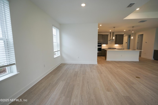 unfurnished living room featuring light hardwood / wood-style flooring and sink