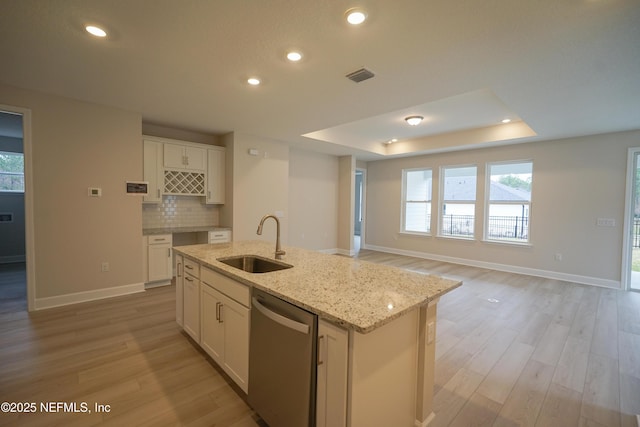 kitchen with a raised ceiling, visible vents, backsplash, a sink, and dishwasher