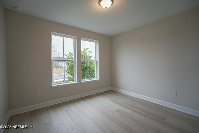 unfurnished room with wood finished floors and baseboards