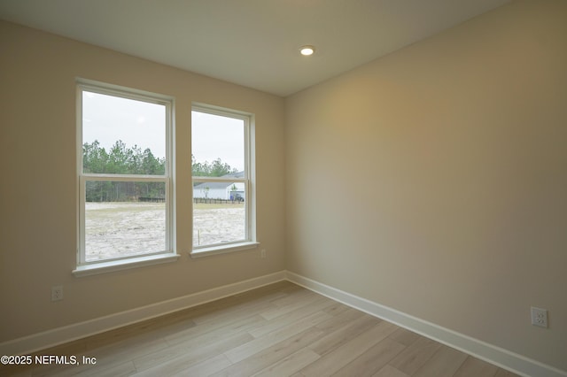 unfurnished room featuring light wood finished floors, recessed lighting, and baseboards