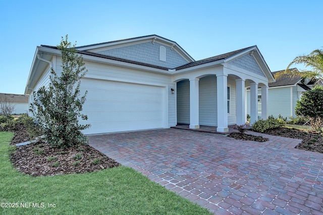 view of front of property featuring a garage and decorative driveway