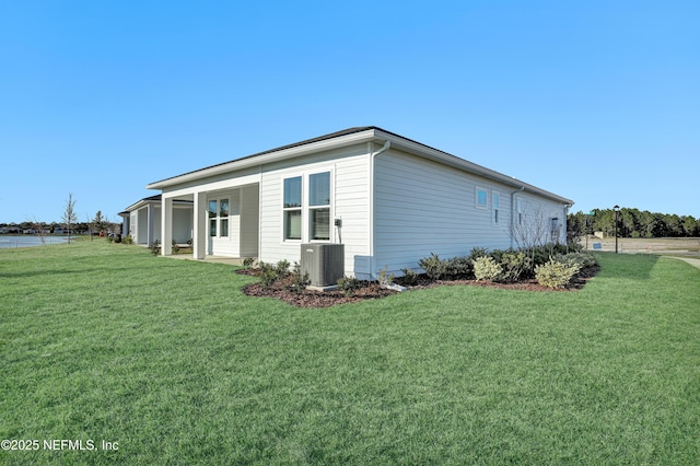 view of side of property with central AC and a yard