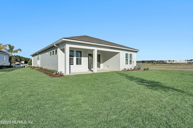 back of property with a lawn, central AC unit, and a patio