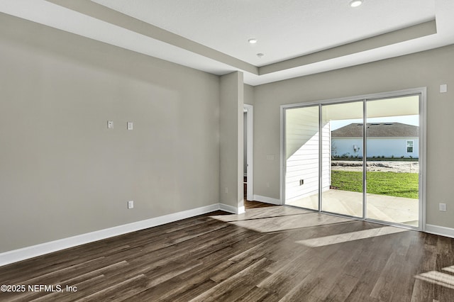 spare room with recessed lighting, dark wood finished floors, and baseboards