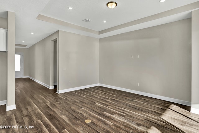 unfurnished room featuring recessed lighting, visible vents, dark wood finished floors, and baseboards