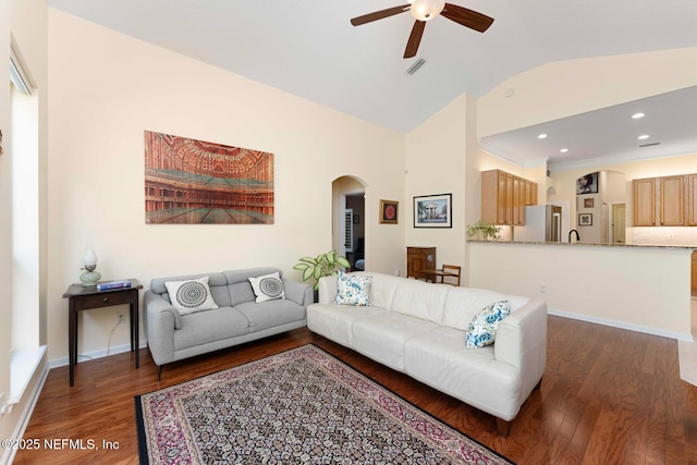 living room featuring ceiling fan, dark hardwood / wood-style floors, and vaulted ceiling