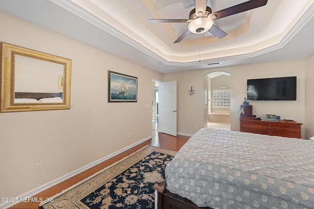 bedroom with hardwood / wood-style floors, a raised ceiling, ceiling fan, and crown molding