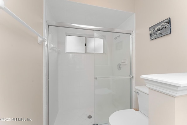 bathroom featuring toilet and an enclosed shower