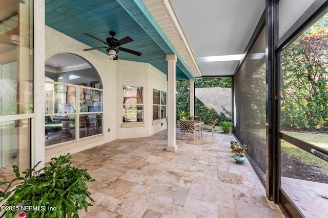 unfurnished sunroom featuring ceiling fan