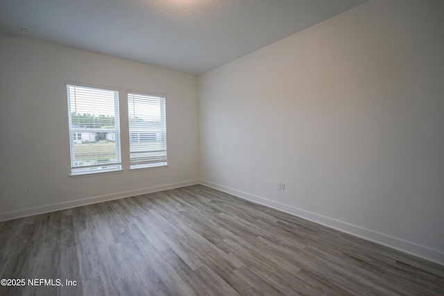 unfurnished room with wood finished floors and baseboards