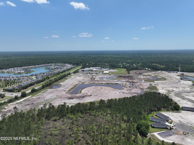 drone / aerial view featuring a water view and a forest view