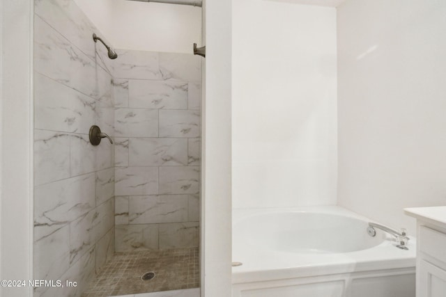 bathroom featuring tiled shower and vanity