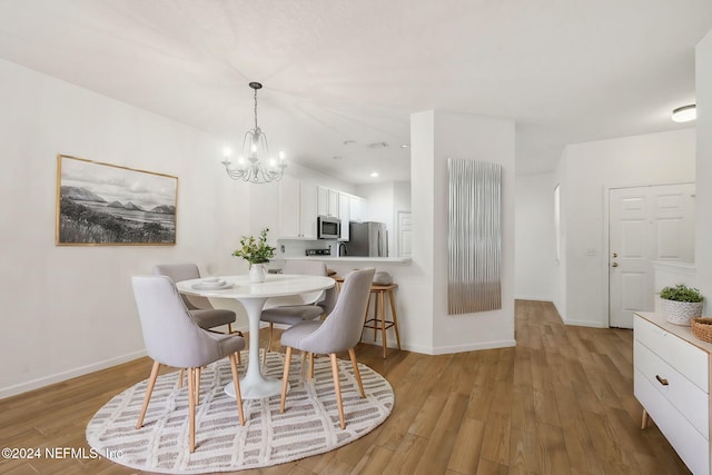 dining area featuring an inviting chandelier and light hardwood / wood-style flooring