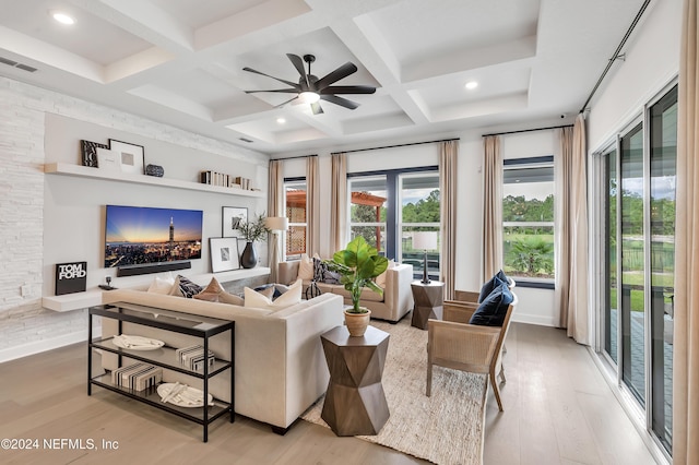 living area featuring light wood-style floors, coffered ceiling, and beamed ceiling