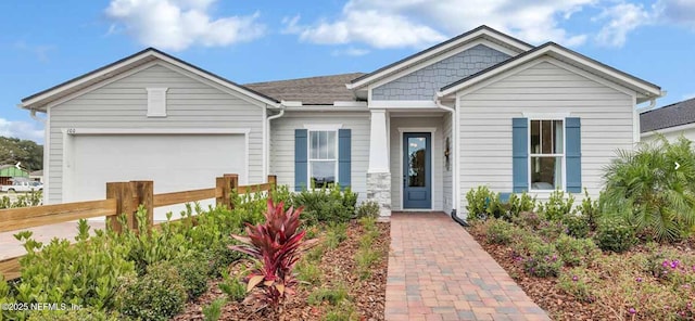 view of front of house featuring an attached garage and fence