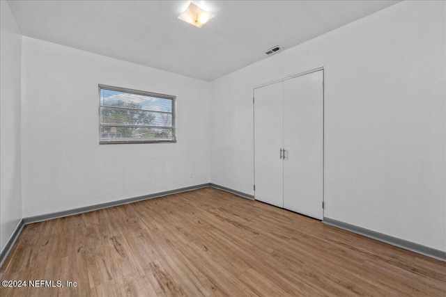 unfurnished bedroom featuring a closet and light hardwood / wood-style flooring