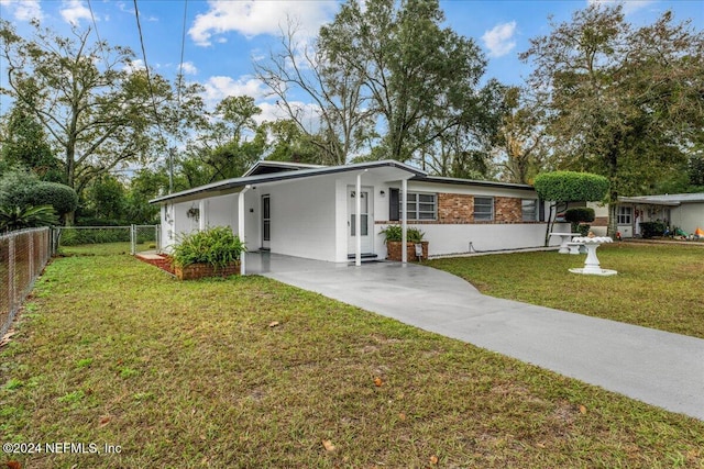 ranch-style home featuring a front lawn and a carport