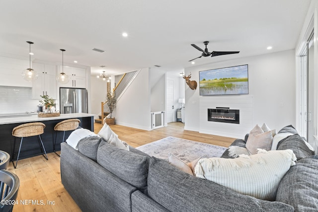 living room with light wood-type flooring and ceiling fan