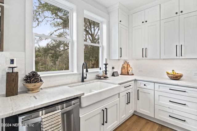 kitchen featuring stainless steel dishwasher, light hardwood / wood-style flooring, and white cabinetry