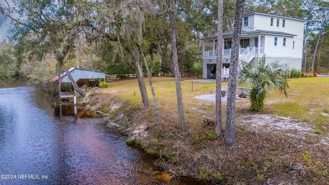 view of yard featuring a dock and a water view