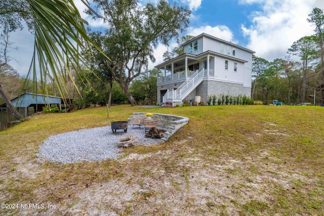 view of yard featuring covered porch and an outdoor fire pit