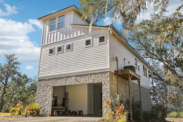 view of side of home with central air condition unit and a garage