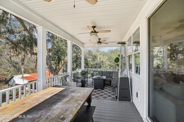 wooden terrace with ceiling fan and outdoor lounge area