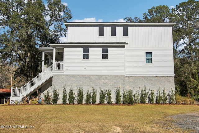 back of property featuring a porch and a yard