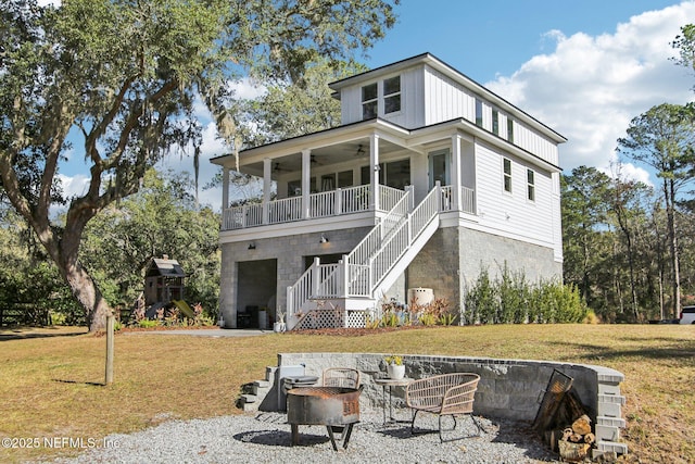 rear view of house with an outdoor fire pit, ceiling fan, and a yard