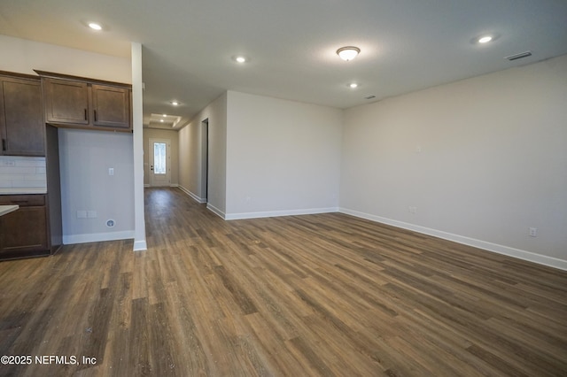 empty room featuring dark wood-style flooring, recessed lighting, visible vents, and baseboards