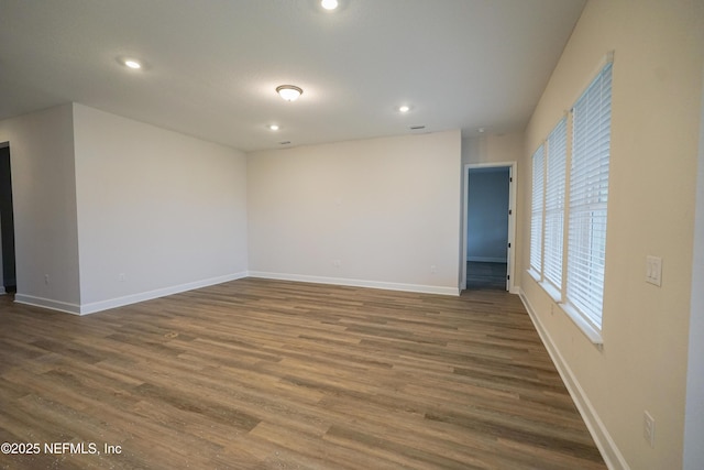 empty room with recessed lighting, wood finished floors, and baseboards