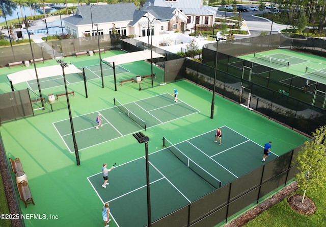 view of tennis court featuring a residential view and fence