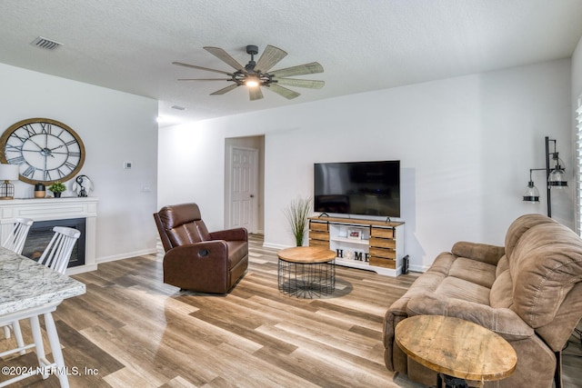 living room featuring wood-type flooring and a textured ceiling