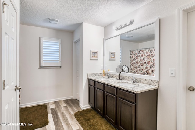 bathroom featuring hardwood / wood-style floors, vanity, and a textured ceiling