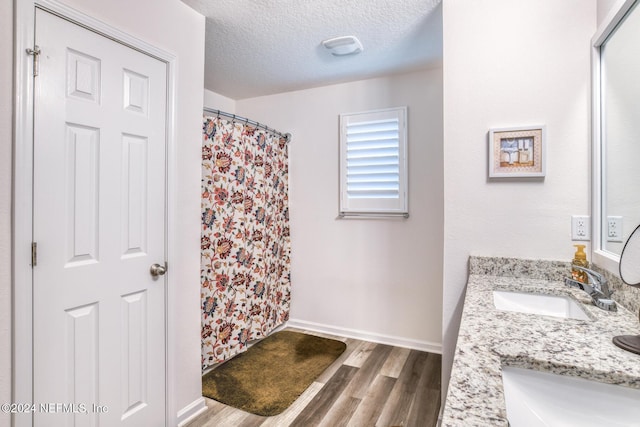 bathroom featuring curtained shower, vanity, a textured ceiling, and hardwood / wood-style flooring