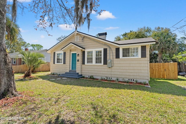 bungalow-style home featuring entry steps, a chimney, a front yard, and fence