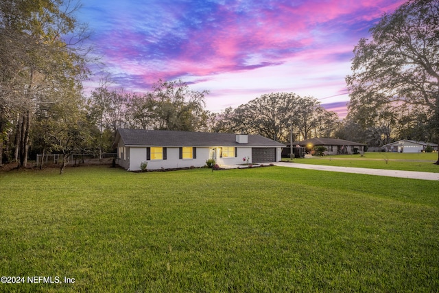 ranch-style house with a yard and a garage