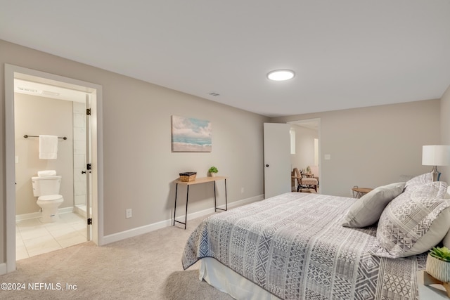 bedroom with ensuite bath and light colored carpet