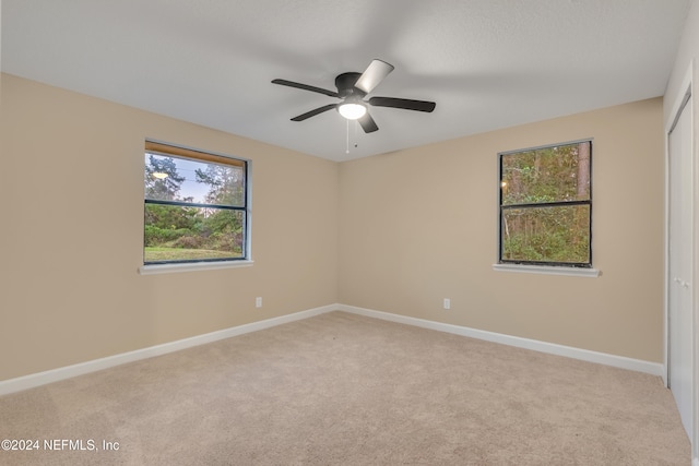 unfurnished room featuring light colored carpet and ceiling fan