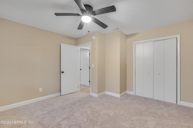 unfurnished bedroom featuring a closet, ceiling fan, and light colored carpet