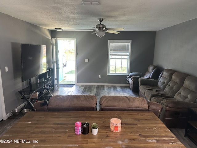 living room with hardwood / wood-style floors, ceiling fan, and a textured ceiling