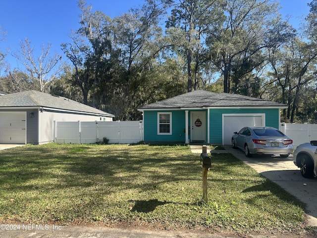 single story home featuring a garage and a front lawn