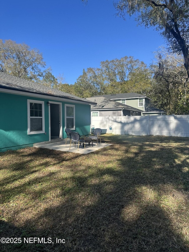 rear view of house with a patio area and a lawn