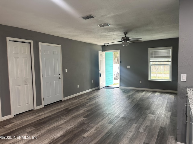 unfurnished room featuring ceiling fan, dark hardwood / wood-style floors, and a textured ceiling