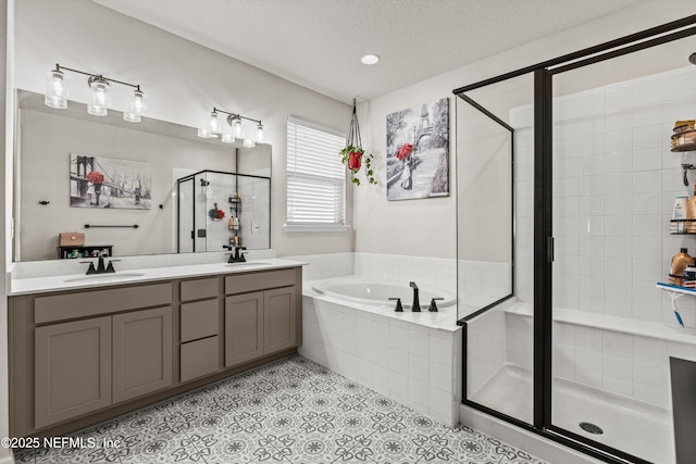 bathroom with tile patterned floors, vanity, independent shower and bath, and a textured ceiling